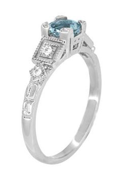 This classic 1920's vintage design Art Deco aquamarine engagement ring in 18K white gold features a beautiful round natural aquamarine ( March Birthstone ) of 0.75 carat, in a secure 4 prong fishtail setting. Four shimmering round side diamonds of F/G color and VS clarity totaling 0.06 carat are embedded in square Deco geometric frames to perfectly complement the center aquamarine stone.Measuring 5.4 mm wide at the top of the ring and tapering down to 1.7 mm wide at the bottom of the band, this Classic Light Blue Topaz Ring For Anniversary, Classic Light Blue Rings For Anniversary, Classic Aquamarine Diamond Ring, Classic Gia Certified Round Topaz Ring, Classic Light Blue Topaz Ring, Classic Light Blue Diamond Ring, Classic Diamond Ring With Aquamarine Accent Stones, Classic Aquamarine Rings With Diamond Cut, Classic Aquamarine Diamond Ring With Accent Stones