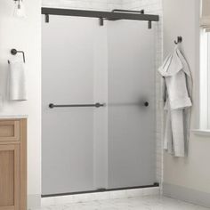 a white bathroom with a glass sliding shower door