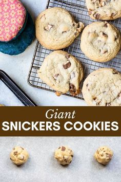 chocolate chip cookies on a cooling rack with the words giant snickkers cookies above them