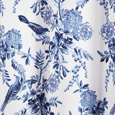 a blue and white flowered curtain with birds on it