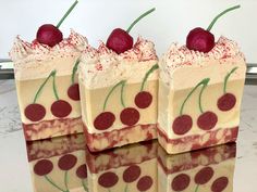 four pieces of cake with cherries on top