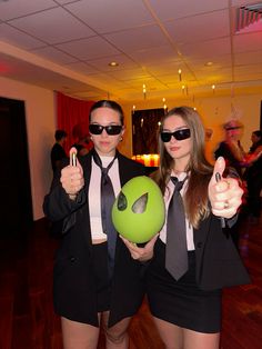 two people dressed in suits and ties holding bowling balls