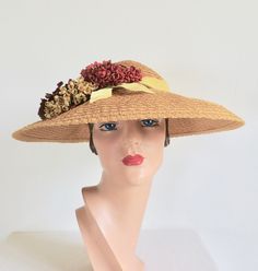 "This is an outstanding example of a late 1940's to 50's sun hat. Made  in a caramel colored woven straw. Shallow crown and a wide down turned brim. Exquisitely trimmed with yellow and orange velvet ribbon as well as yellow, orange and corral small felt flower bouquets on the side front and a green tassel like ornament. Interior hat is trimmed with yellow grosgrain ribbon. Perfect for a garden party or the races! **Ask me about International shipping rates. Label:  Roberta Bernays Condition:  Excellent.  Looks barely worn if at all. Size/Measurements: crown height-  3\" brim diameter-  16\" inside crown-  21\"" Accessories Matching, Felt Flower Bouquet, Large Brim Hat, Types Of Hats, Orange Velvet, Fashion 1950s, Fancy Hats, Felt Flower, Caramel Color