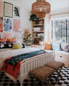 a bed room with a neatly made bed and lots of pictures on the wall above it