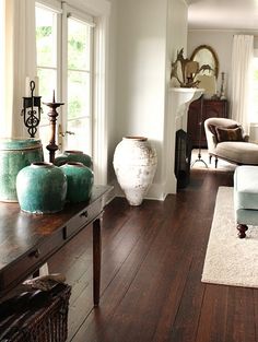 a living room filled with lots of furniture and decor on top of hard wood floors