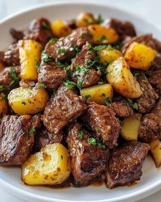 a white plate topped with meat and potatoes