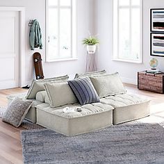 a living room filled with lots of furniture and decor on top of a hard wood floor