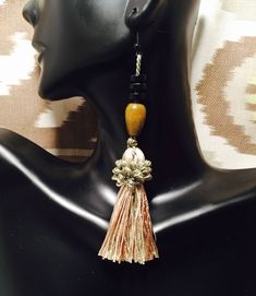 Beautiful unique tassels accented by brown and black wooden beads. Tassel is made with variations of teal, caramel brown, and teal for a neutral color effect. Nickel and lead free fish hook. 100% Rayon tassels. Hangs 4.5". Elegant Brown Adjustable Tassel Earrings, Adjustable Brown Bohemian Tassel Earrings, Beach Jewelry With Brown Tassels, Elegant Brown Dangle Tassel Earrings, Bohemian Brown Beaded Tassel Earrings, Brown Dangle Earrings With Tassels, Bohemian Brown Tassel Earrings, Brown Bohemian Tassel Earrings, Brown Dangling Bead Earrings For Beach