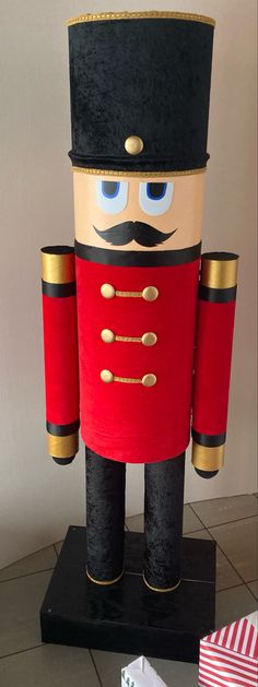 a nutcracker is standing on top of a black stand with red and gold trim