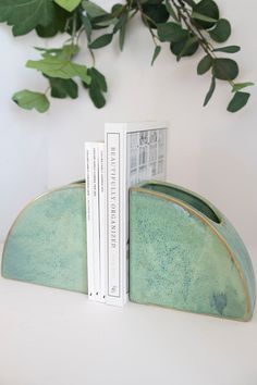 two bookends sitting next to each other on a white table with green leaves