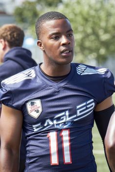 a young man wearing a football uniform on the field