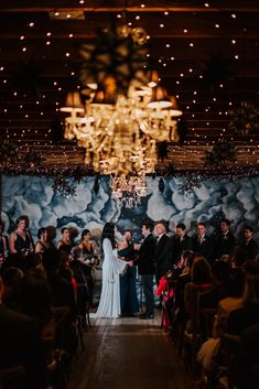 a bride and groom are standing in front of the wedding ceremony crowd at their reception