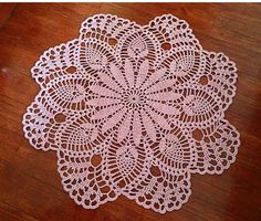 a pink doily sitting on top of a wooden floor