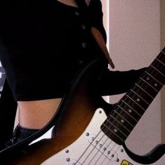 a woman in black shirt holding an electric guitar