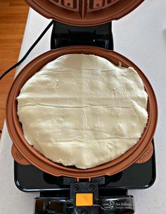 a pancake being made in a waffle iron on top of a countertop