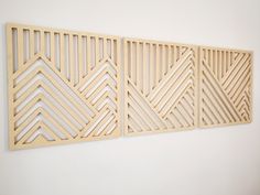 three wooden wall art pieces on a white wall