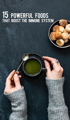 a person holding a cup with green tea in front of some donuts on a plate