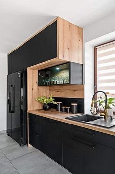 a kitchen with black cabinets and wooden counter tops, along with a sink in the center