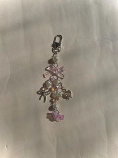 a pink and silver charm with charms attached to it's sides on a piece of paper