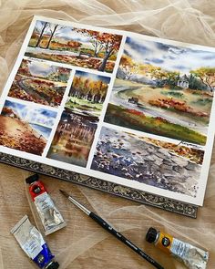 some watercolors are laying out on a table with paint and other items nearby