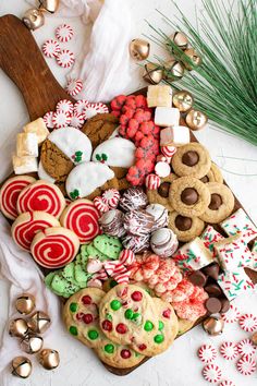 an assortment of christmas cookies and candy on a platter next to other holiday treats