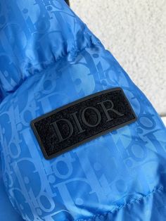 Embrace the essence of luxury with this inspired Dior Oblique Quilted Down Jacket in a striking blue hue. Featuring a sophisticated all-over monogram pattern reminiscent of a high-fashion favorite, this jacket effortlessly combines warmth and style. Its classic puffer design with a stand-up collar and zip closure provides both comfort and protection from the elements. Elevate your everyday look with this statement piece that captures the spirit of iconic design. Please note: This is an inspired Dior Oblique, Monogram Pattern, Bottega Veneta Shoulder Bag, Central African, Iconic Design, Blue Hues, Ethiopia, Caribbean Netherlands, Everyday Look