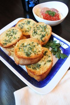 small muffins on a blue and white plate next to a bowl of sauce