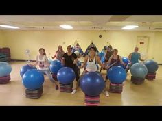 a group of people sitting on top of blue balls