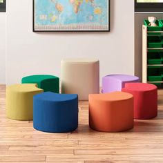 several colorful stools in front of a map on the wall