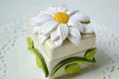 a white flower sitting on top of a box