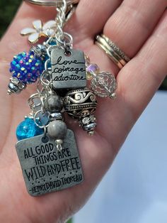 a hand holding a bunch of charms in it's palm with words on them