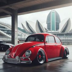 a red vw bug parked in front of a building