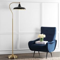 a living room with a blue chair and a gold lamp on the floor next to it