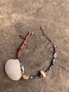 Cockle and drill shell ankle bracelet. Glass and brass beads. Bronze cross charm. 9 1/2" expandable to 11 1/2" double stranded leather ankle bracelet. Hand crafted silver plated hook and ring closure. Adjustable Beaded Bracelets With Charms For Beach, Adjustable Shell Jewelry Nickel Free, Adjustable Nickel-free Shell Jewelry, Adjustable Beaded Shell Jewelry, Adjustable Shell-shaped Nickel-free Jewelry, Nickel-free Adjustable Shell Jewelry, Adjustable Hand Wrapped Shell Jewelry, Adjustable Beaded Bracelet With Lobster Clasp For Festival, Adjustable Metal Jewelry For Beach