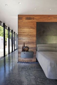 a bed sitting next to a wooden wall in a bedroom