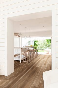 an open kitchen and dining room with wood flooring on the outside side of the house