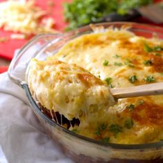 a casserole dish in a glass bowl with a wooden spoon