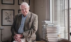 an older man sitting on a chair in front of a window next to a stack of books