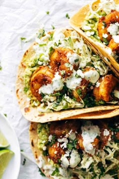 three tacos with shrimp and cilantro on top