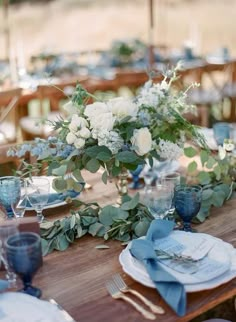 the table is set with blue and white flowers