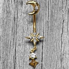 a gold crescent and star belly button ring with crystal stones on it's side