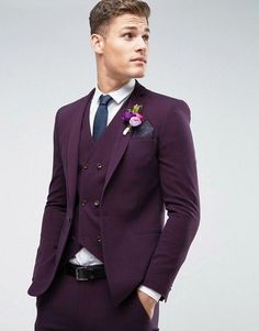 a man in a purple suit with a flower on his lapel