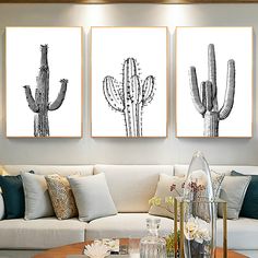 three black and white cactus prints on a wall above a couch in a living room