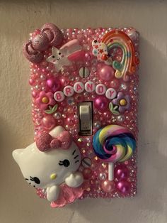 a hello kitty light switch cover with candy, candies and other items on it