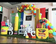 an office decorated with balloons, crayons, and birthday cakes on display