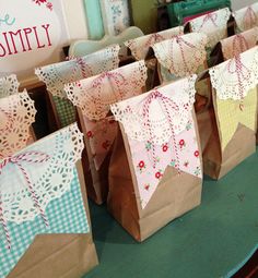 paper bags with doily on them sitting on a table in front of a sign