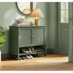 a green cabinet with shoes on it and a lamp next to it in front of a door