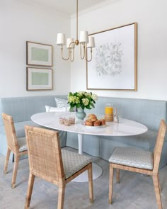 a dining room table with chairs and a bench in front of it, surrounded by pictures on the wall