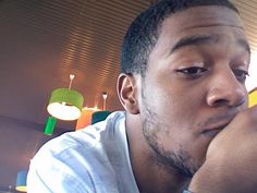 a close up of a person sitting at a table with food in front of him