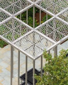 an aerial view of several metal structures in the middle of a garden with trees and plants